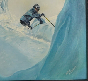 A framed art print depicting a skier inside a blue ice cave, mounted on a plain white wall.