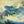 Artistic depiction of a large wave with a coastal scene in the background