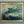 Framed painting of a wave with palm trees on a gray wall