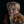 Child with tribal face paint holding a stuffed animal against a black background