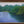 Framed painting of a river surrounded by green trees