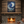 Stone fireplace with a painting of a crescent moon and stars above it, in a cozy room.