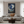 Modern living room with a gray sofa, armchairs, and a decorative painting on the wall.