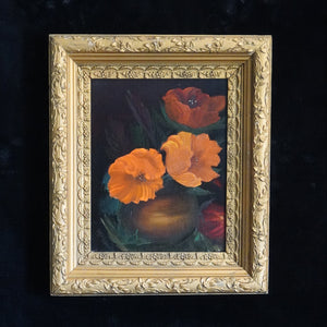 A framed still life painting featuring vibrant orange and red poppies in a dark vase, enclosed in an ornate gold frame and displayed against a dark textured background.