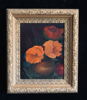 A framed floral painting featuring orange and red poppies in a dark background, housed in an ornate gold frame, displayed against a dark textured wall.