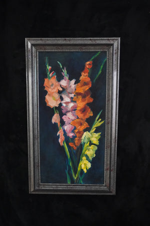 A framed vertical oil painting of gladiolus flowers in shades of orange, pink, and yellow against a dark background, housed in a distressed dark gray frame.