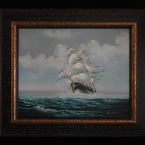 Where Courage Sails painting of a white-sailed ship on teal waves beneath cloudy skies, in a dark frame with gold trim.”
