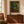 Where the Garden Keeps Its Secrets framed painting displayed on a wall above an antique wooden chest in a cozy reading corner