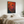 Lifestyle mockup of The Crimson Challenge abstract rooster painting hanging above a bed in a bedroom